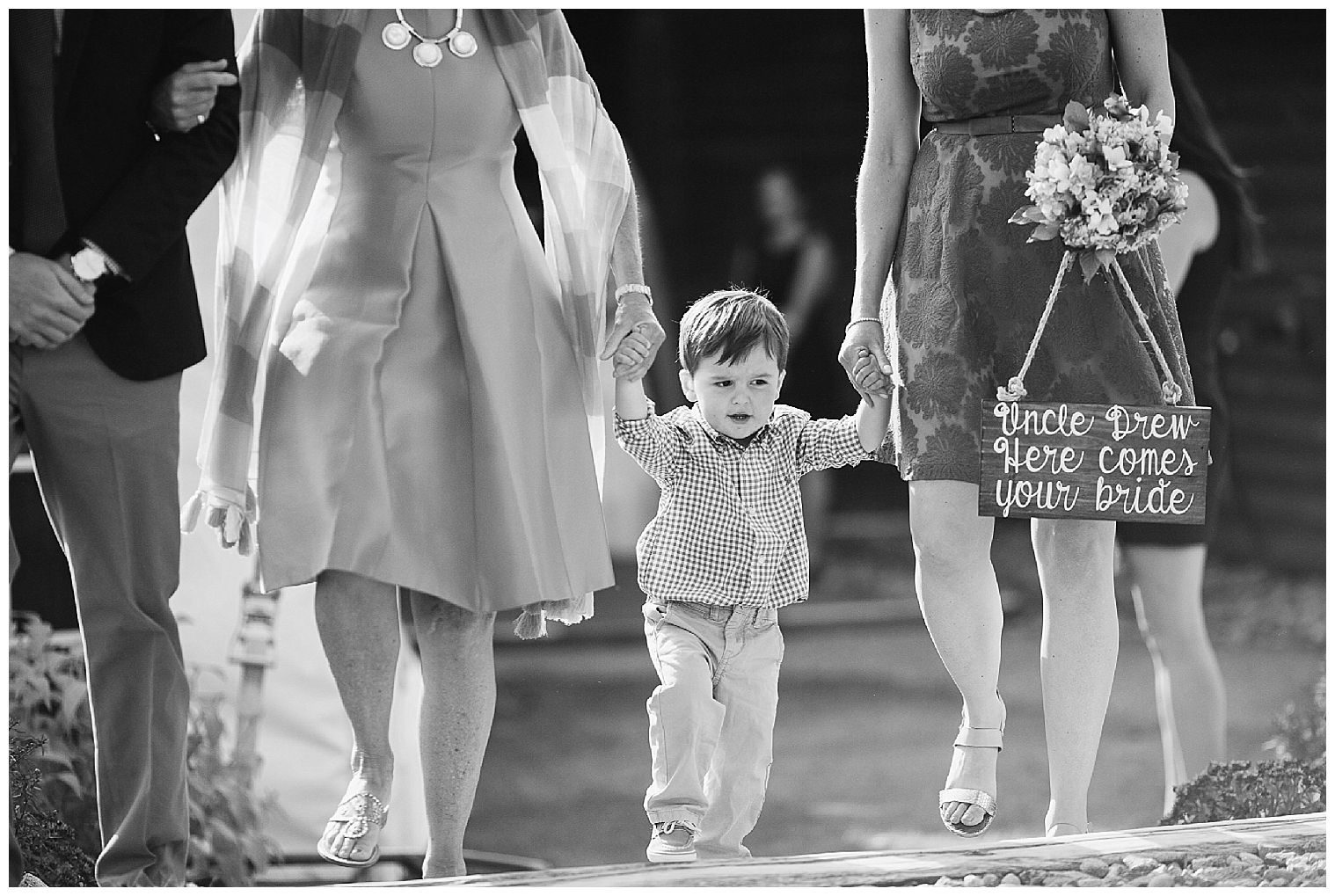  Un niño es ayudado por el pasillo con un letrero de "viene la novia" en una ceremonia de boda de Piedra Angular.