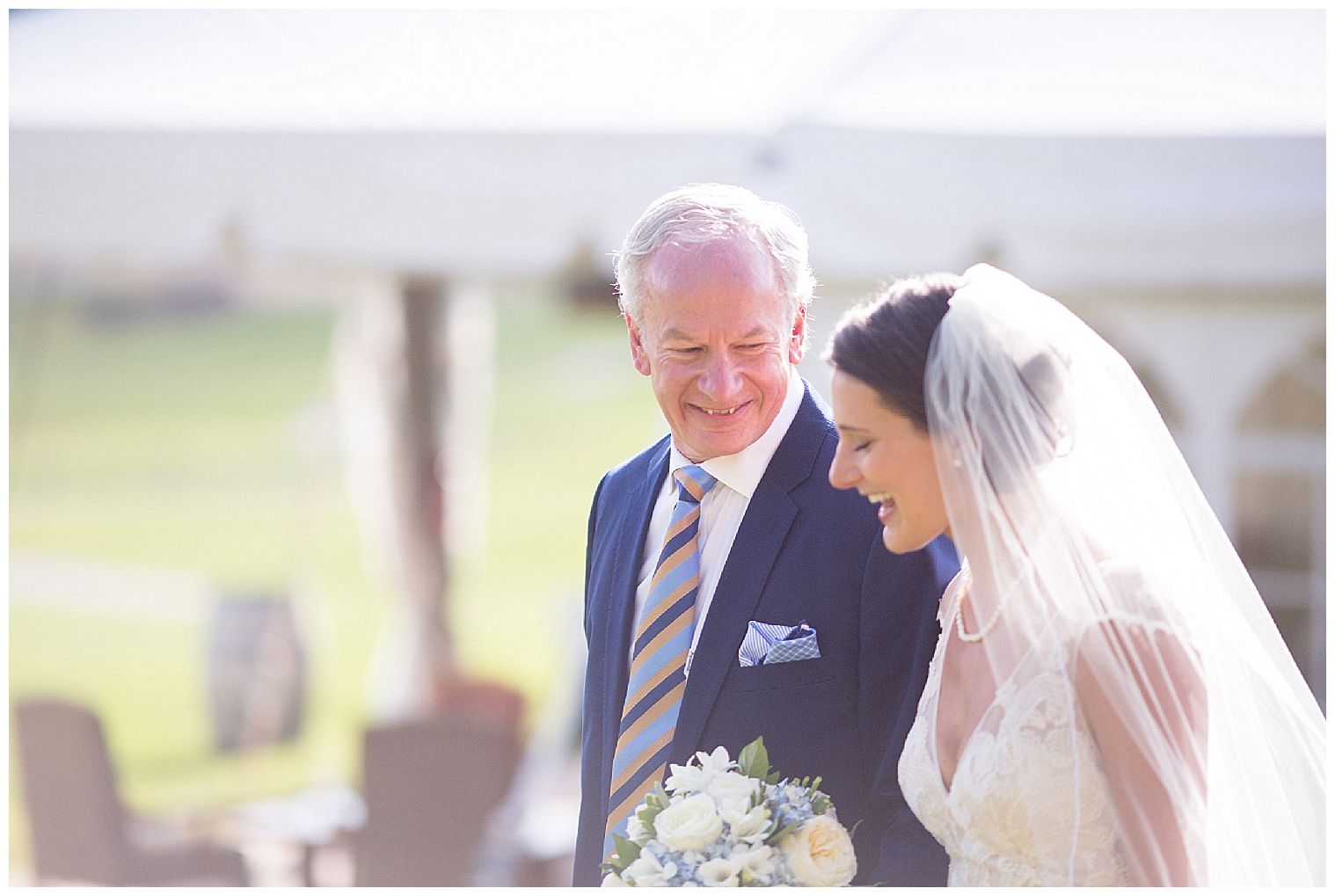  o pai da noiva sorri para sua filha enquanto a caminha pelo corredor no local da cerimônia de casamento Keystone Ranch.