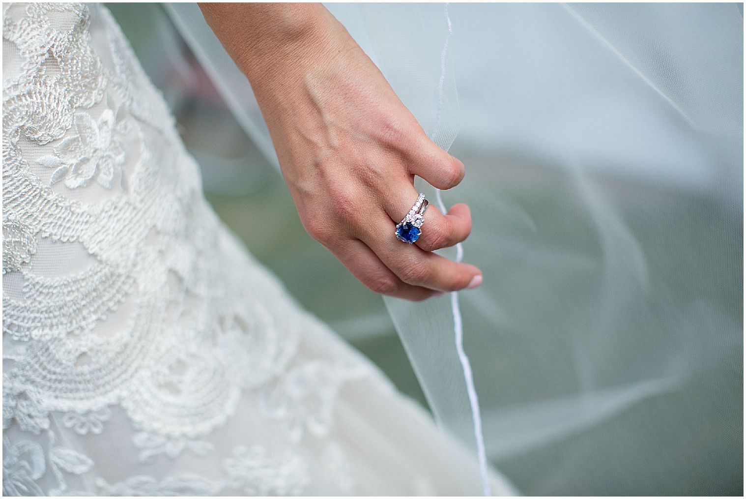  Photo en gros plan de l'alliance bleue de la mariée pendant qu'elle tient son voile. 