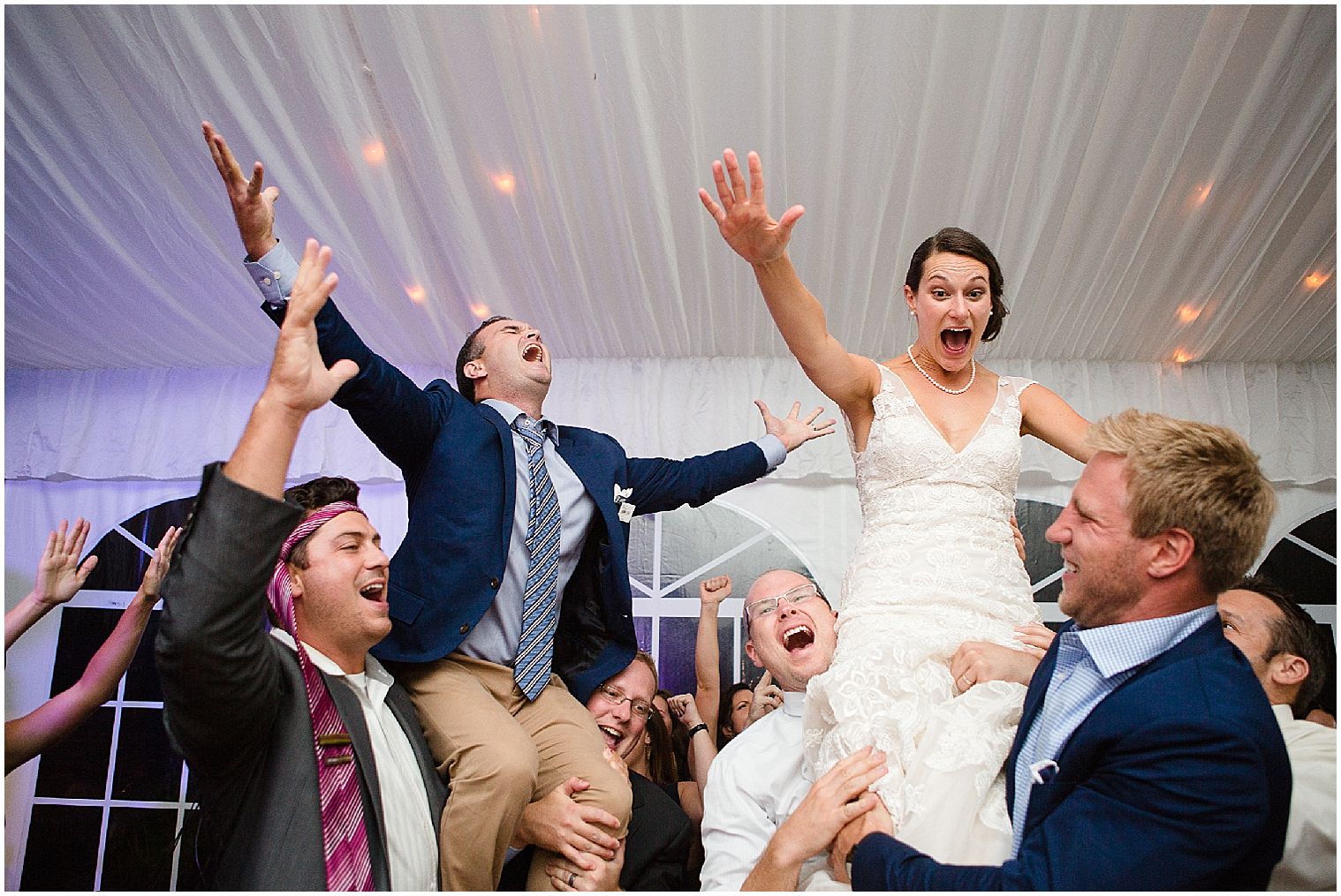 Gäste einer Keystone Ranch Hochzeit hissen Braut und Bräutigam während der Empfangsparty auf ihre Schultern.