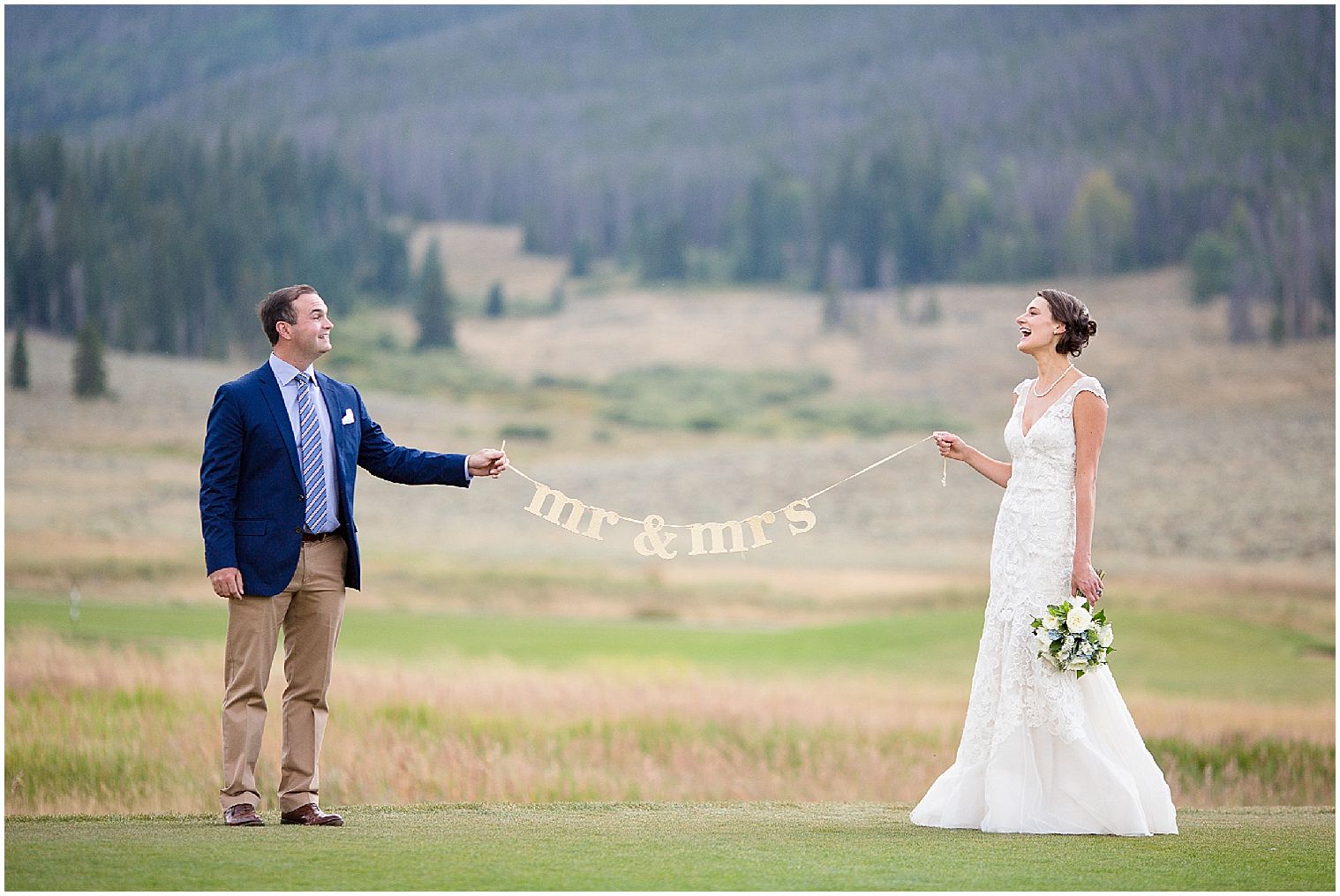  Los novios sostienen una pancarta de "sr. sra." en su boda en Colorado Mountain en Keystone.