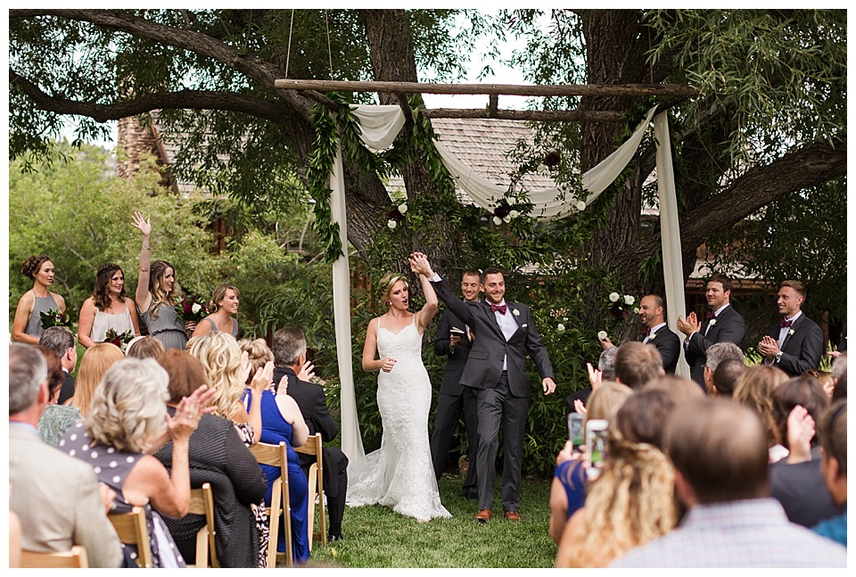 bride and groom cheer with hands up after their wedding ceremony at spruce mountain ranch
