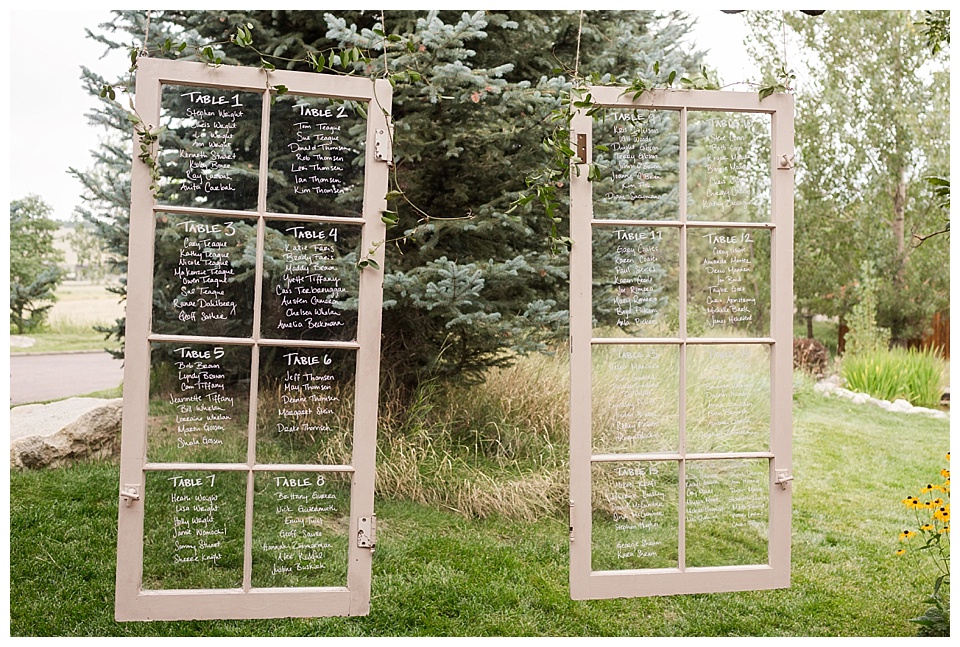 hanging glass windows with seating chart in calligraphy