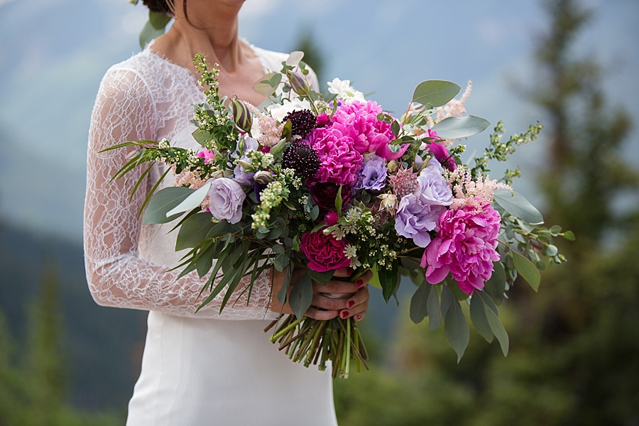 bride poses with her stunning colorful bridal bouquet in aspen