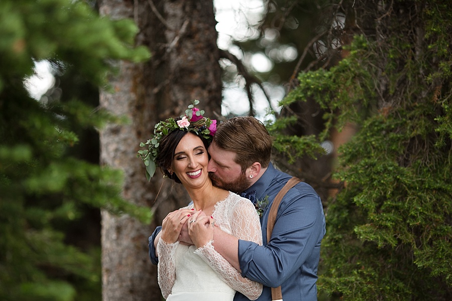 groom kisses bride's neck in the mountains of aspen 