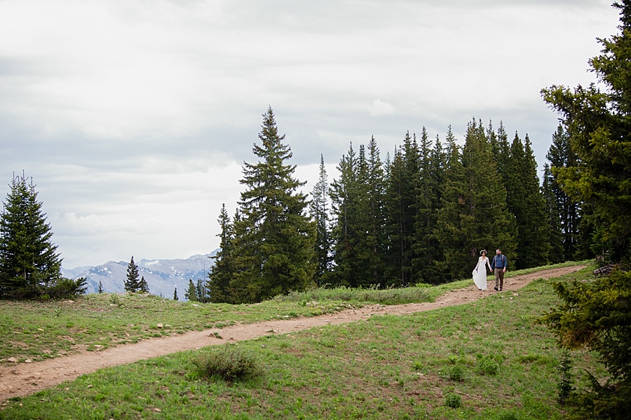 bride and groom walk through the mountains of aspen after their summer elopement 