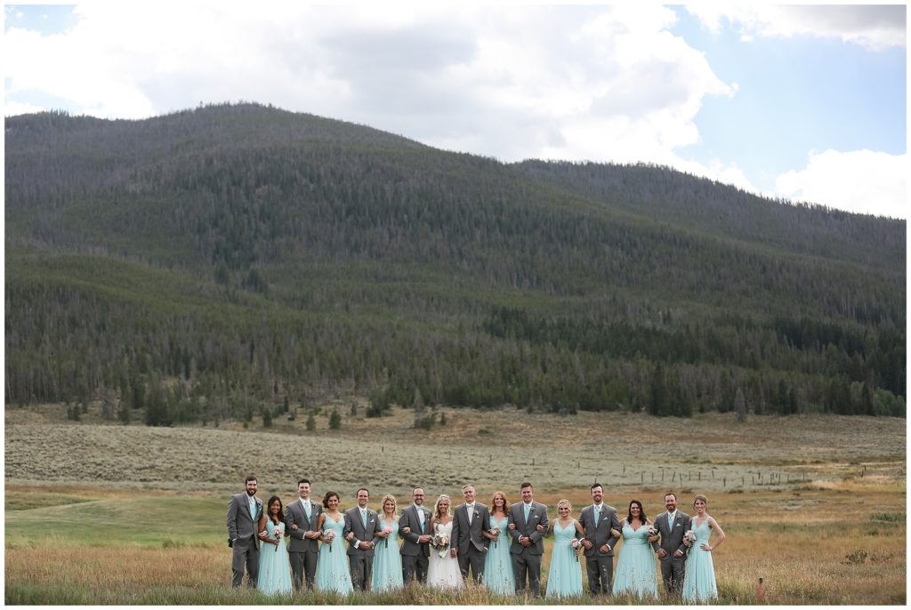 bridal party posing in front of Colorado mountains at keystone ranch colorado