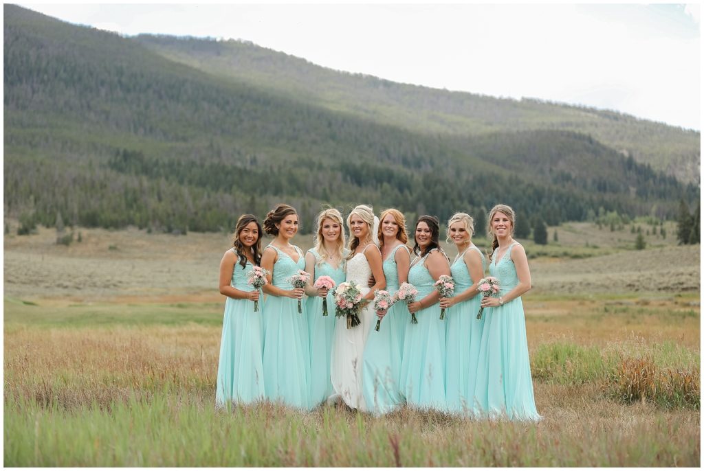 bride with bridesmaids wearing turquoise bridesmaid dresses with succulent flowers at keystone ranch colorado