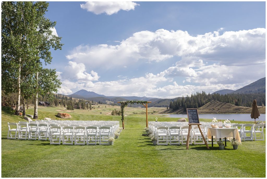 wedding ceremony venue with mountain background with greenery covered arbor in keystone ranch colorado