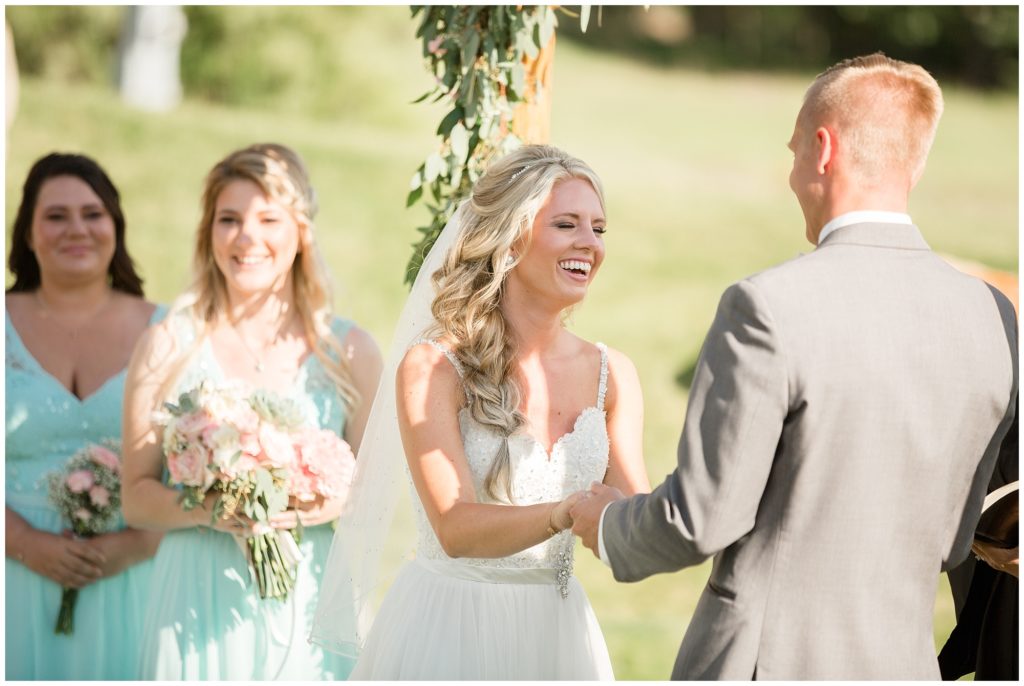 bride laughing during her summer wedding ceremony at keystone ranch colorado