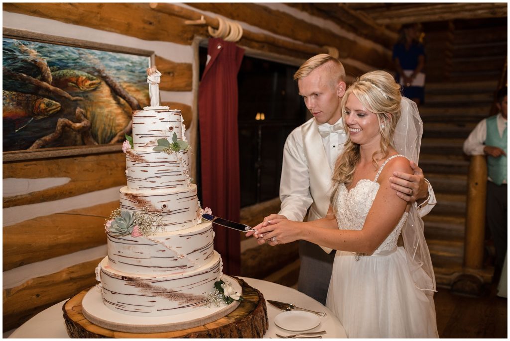 bride and groom cut into their mountain tree wedding cake designed by Ned Archibald