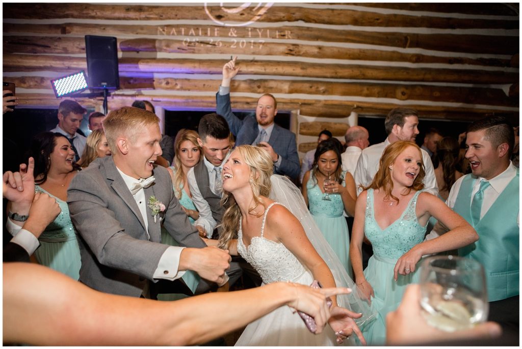 bride and groom surrounded by wedding guests during reception at keystone ranch