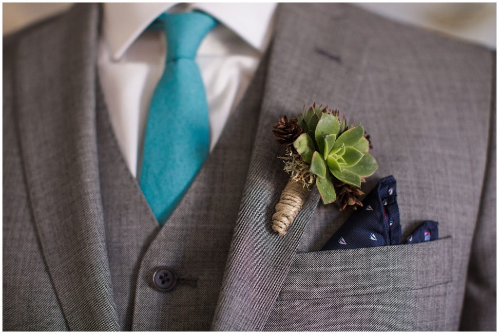 detail of grooms jacket boutonniere and turquoise tie