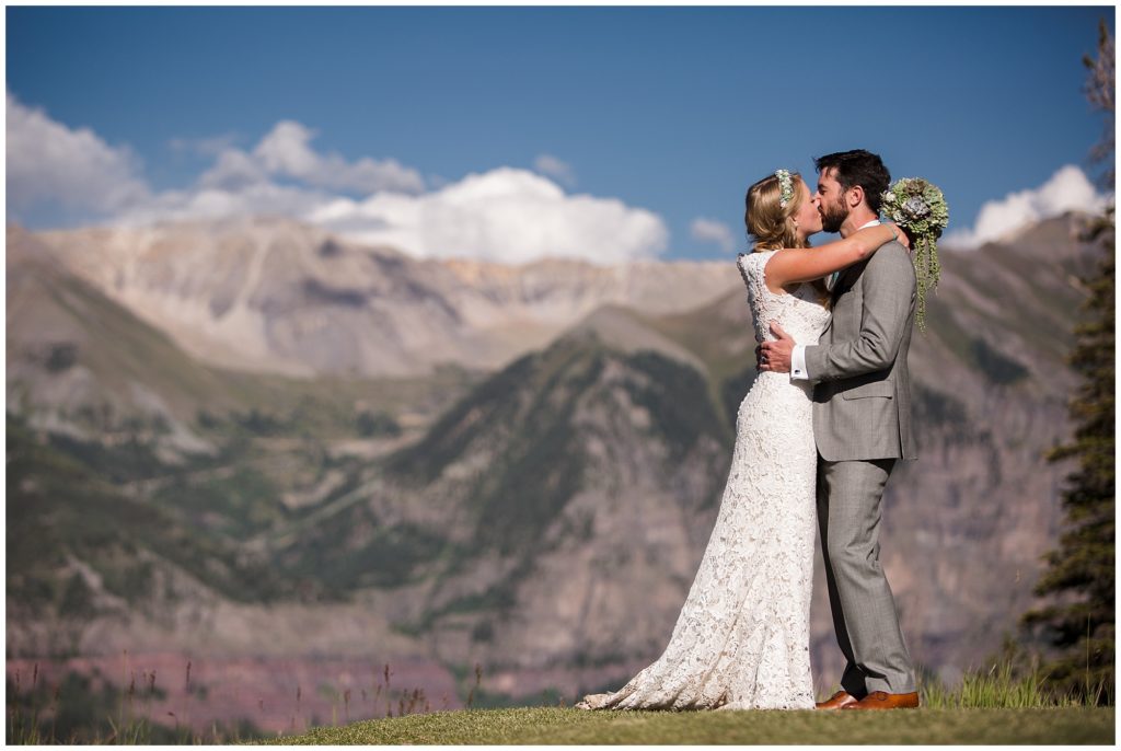 bride and groom kiss during bridal portraits with gorgeous mountains in Telluride 