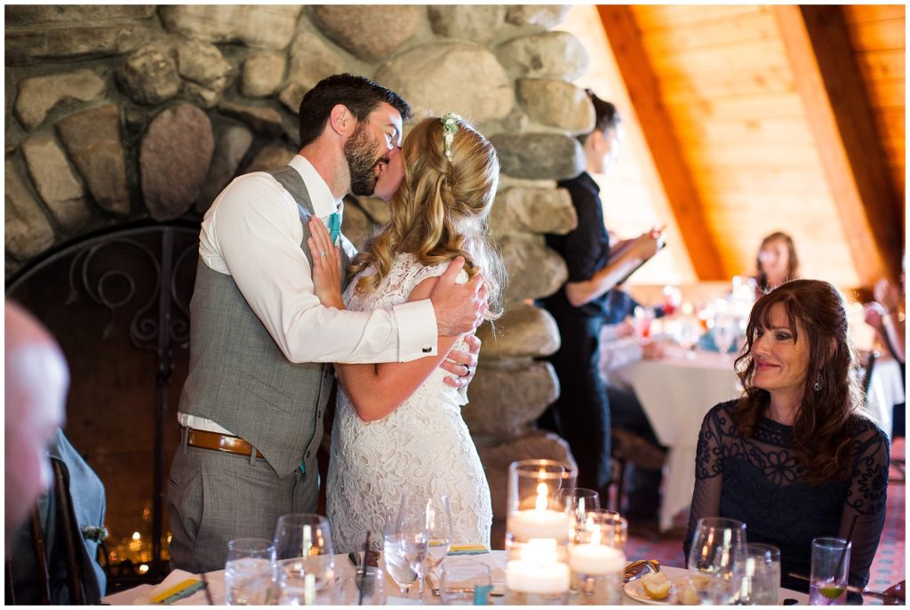 bride and groom kiss during toasts in Telluride 