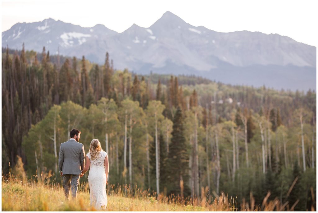 bride and groom walking toward mountains and sunset in Telluride Colorado