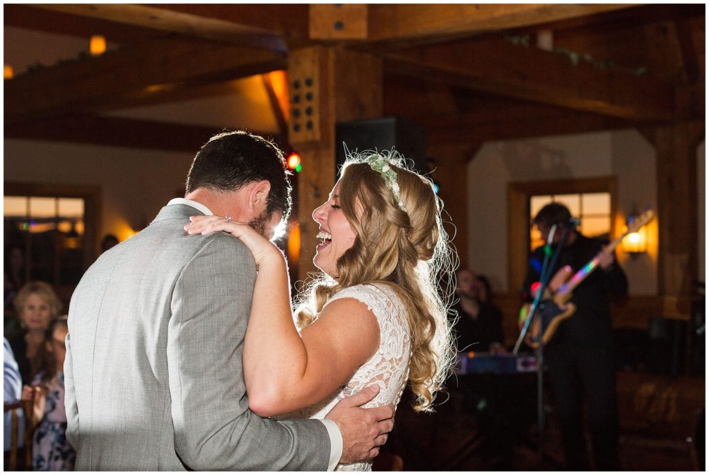 bride laughs while dancing with groom during their first dance