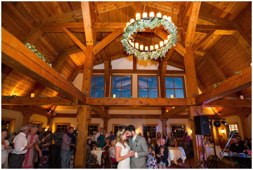 wide shot of bride and groom's first dance with high ceilings and candle chandeliers 