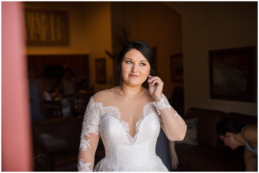 bride putting her earrings in on her wedding day at timber ridge lodge