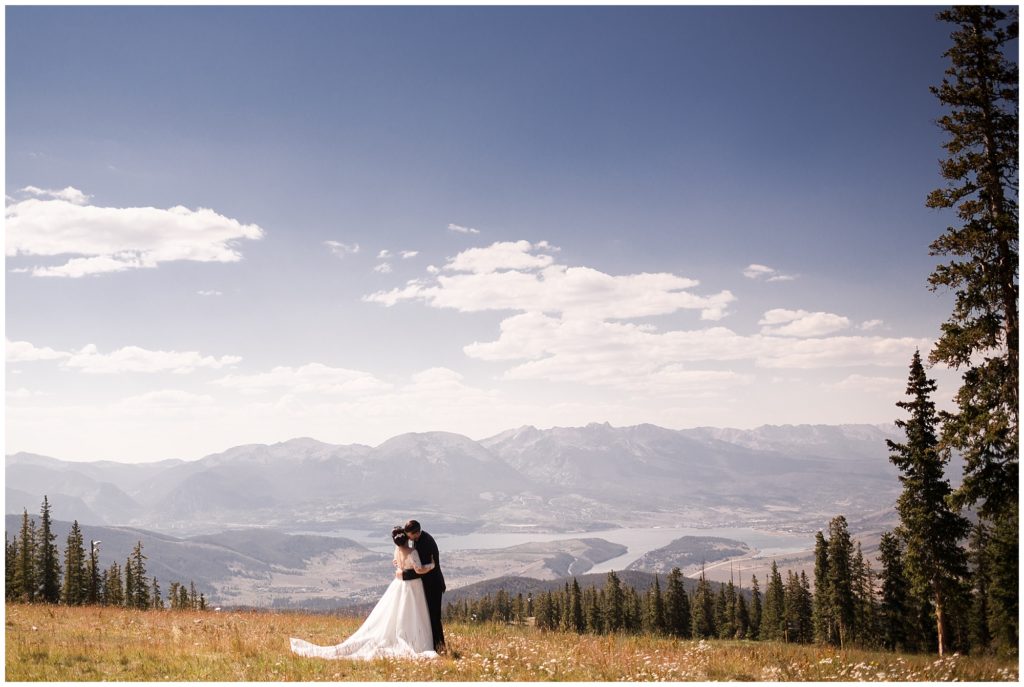 groom kisses bride's neck with stunning Colorado mountain backdrop