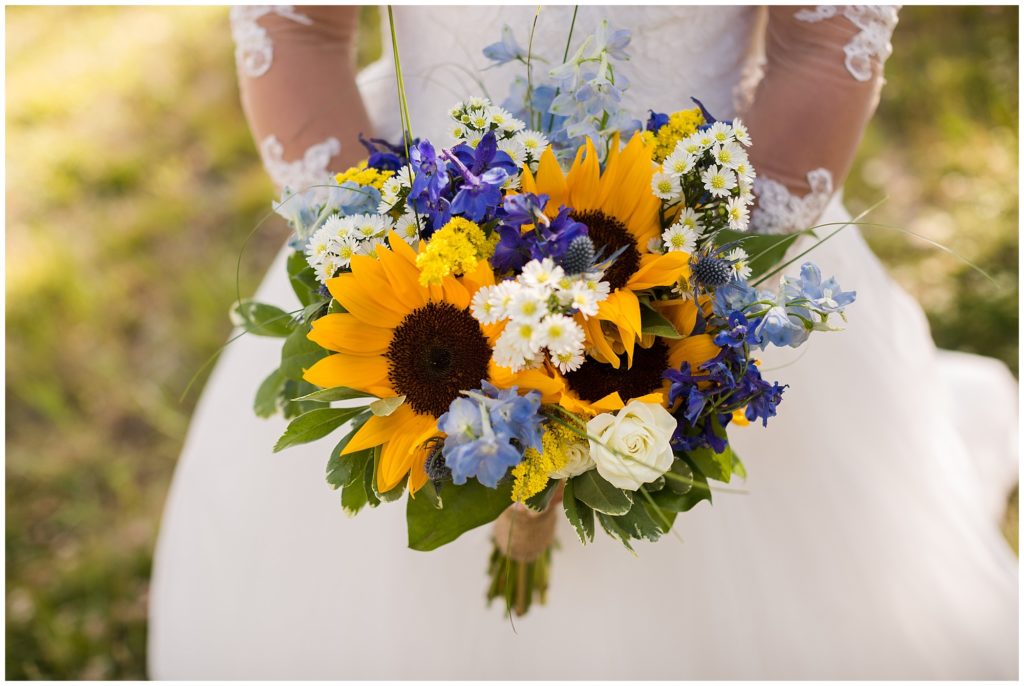 detail of brides wedding florals made of sunflowers, blues and purples 