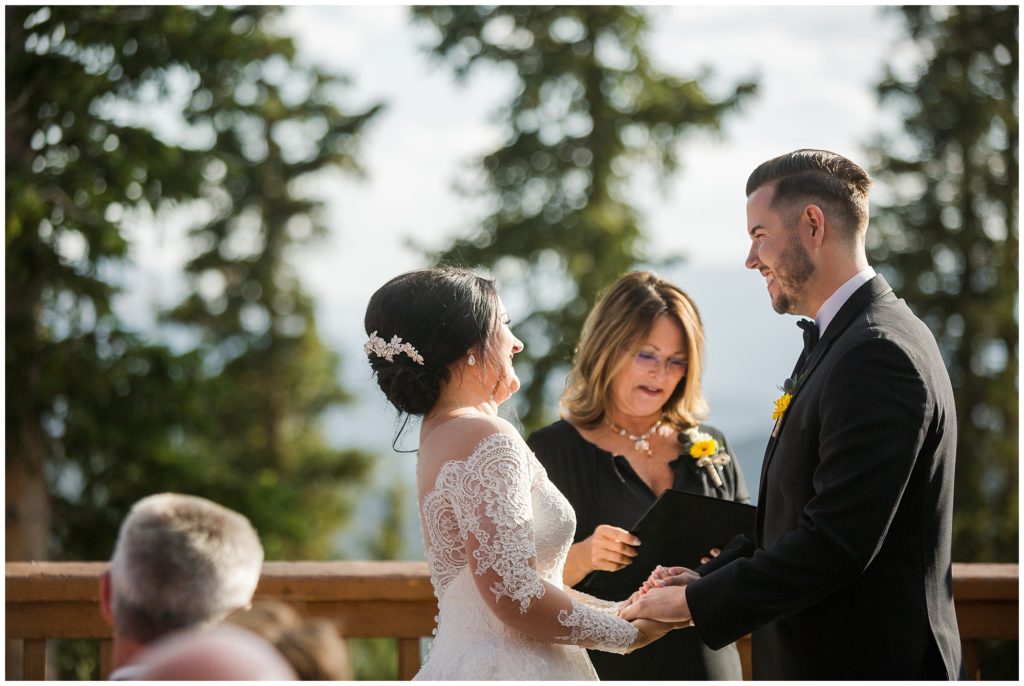bride and groom laugh and hold hands during their outdoor summer wedding ceremony at timber ridge lodge