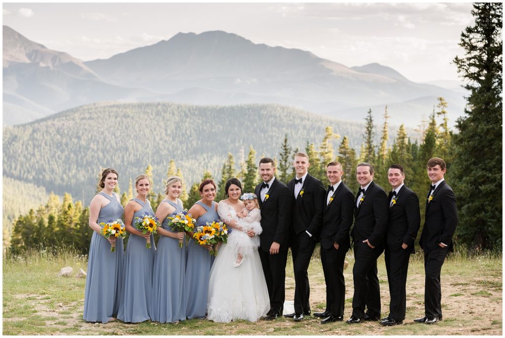 bridal party poses during golden hour with flower girl in keystone Colorado 