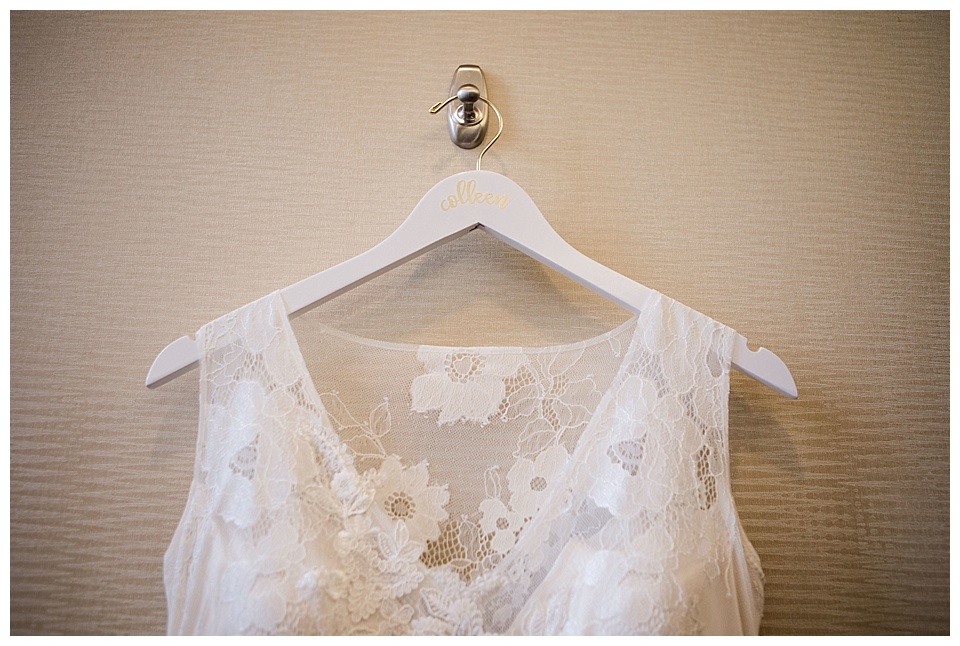 detail of brides wedding dress on white hanger
