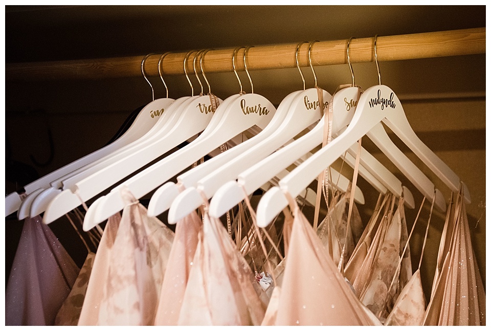 white personalizes bridesmaid hangers with pink dresses