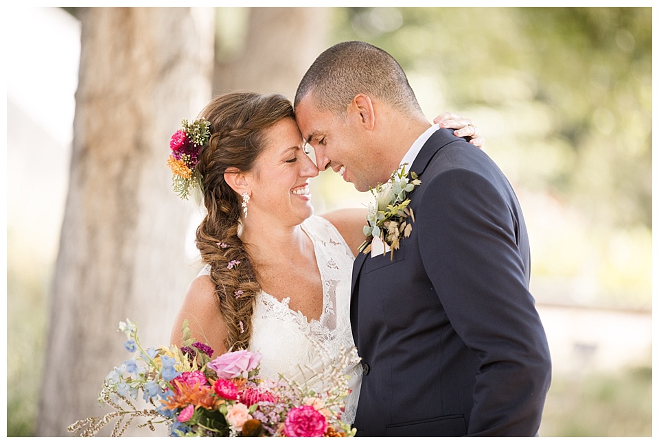 bride and groom touch heads during portraits in denver botanical gardens 