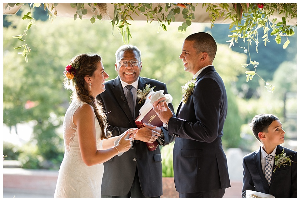 bride and groom laughing during their wedding ceremony at denver botanic gardens 