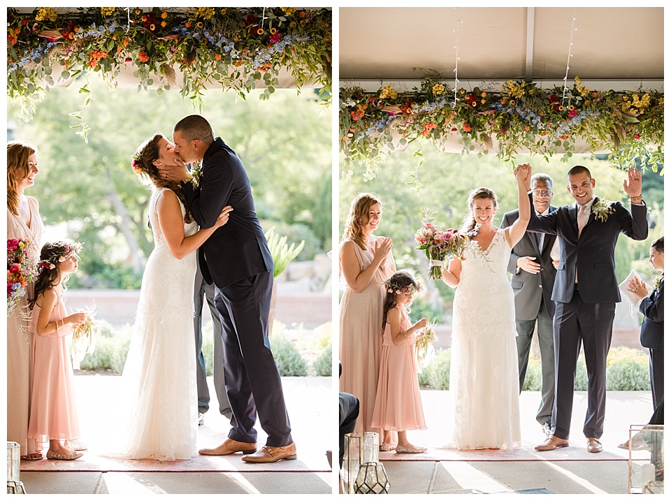bride and groom kiss at the end of their wedding ceremony and cheer