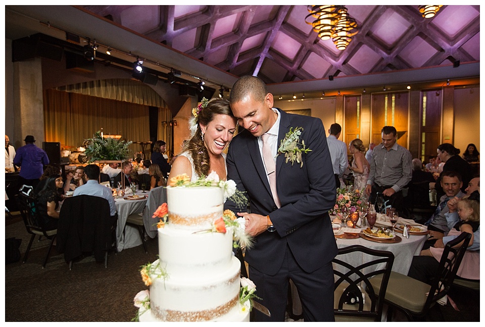 bride and groom cut their wedding cake at their downtown denver wedding reception