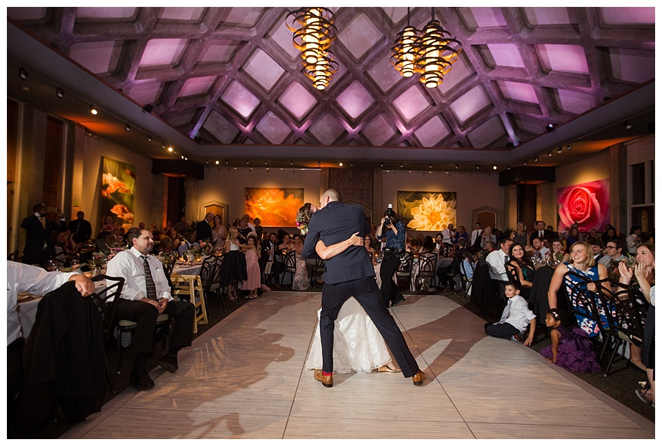 groom dips his bride at the end of their first dance at their downtown denver wedding 