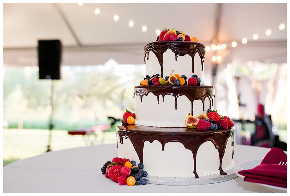 white wedding cake with dripping chocolate and fruit