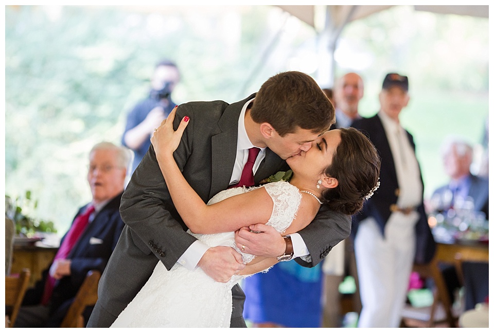 groom dips bride and kisses her during their grand entrance to their reception at oxford road farm