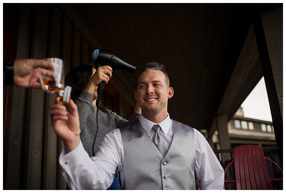 groom taking a shot while getting ready on his wedding day