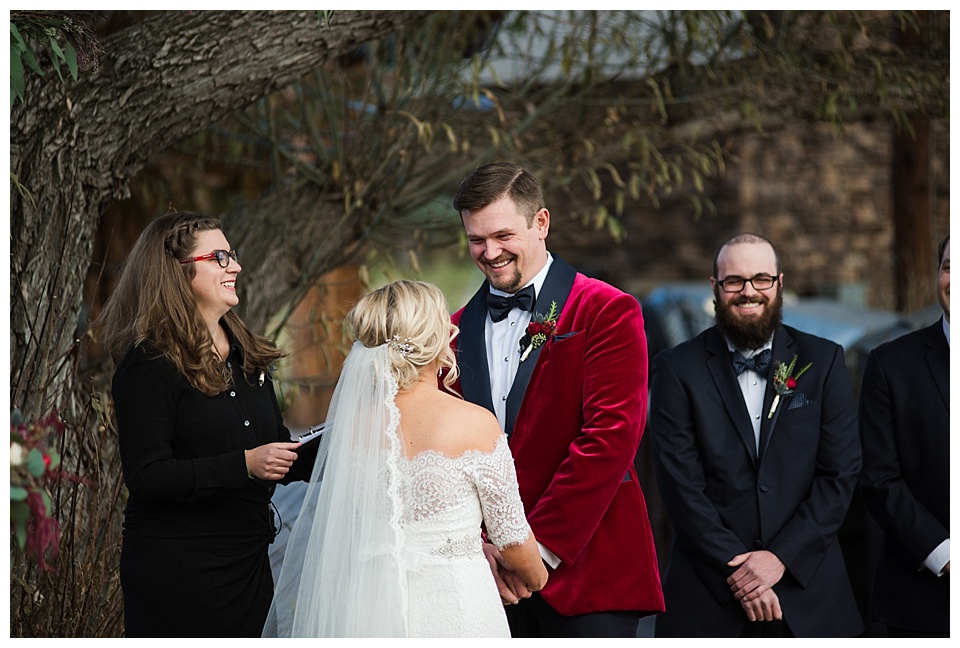 groom laughs with bride during wedding ceremony 