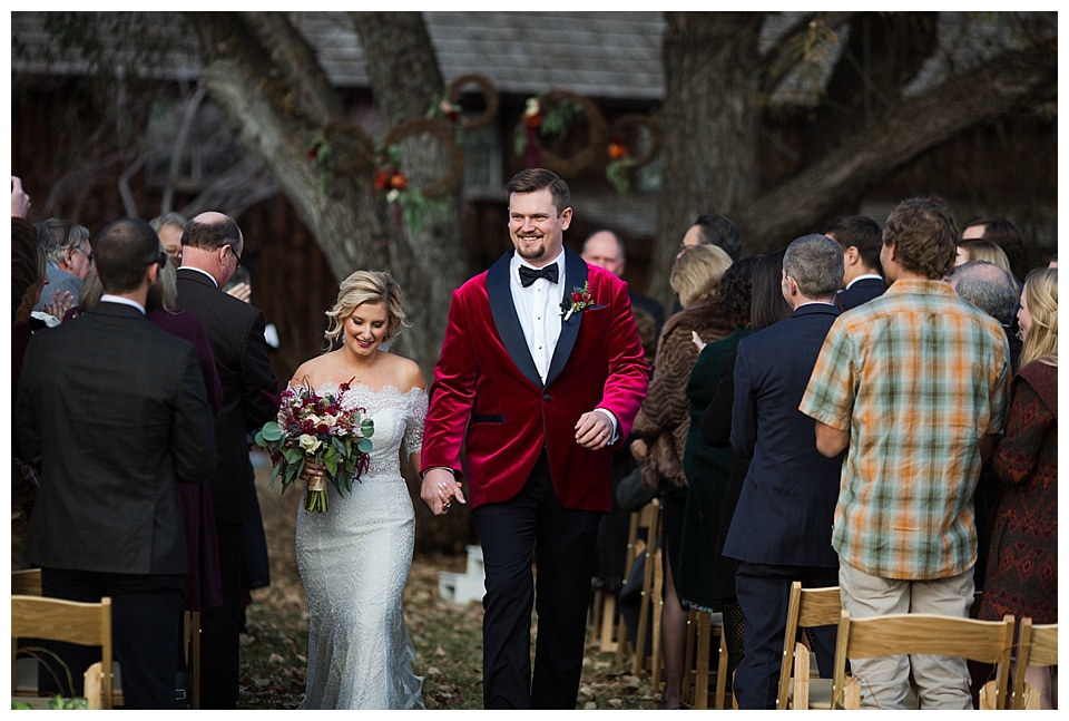 bride and groom exit their fall wedding ceremony at spruce mountain ranch