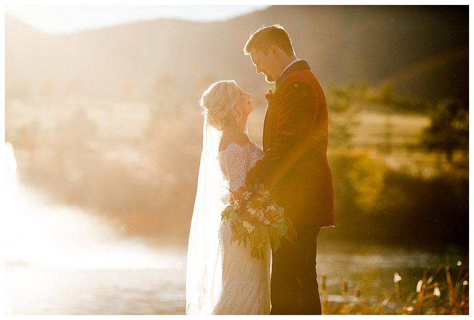 bride and groom look at each other in the sunset at spruce mountain ranch