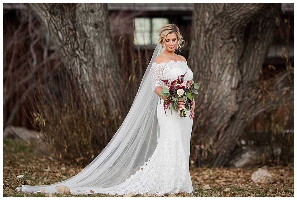 bride poses in front of tree for solo portrait at spruce mountain ranch