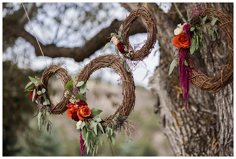 hanging wooden wreaths with greenery and warm florals