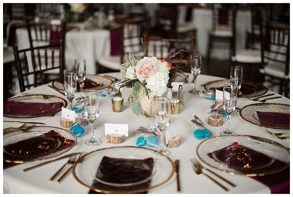 wedding reception tables with clear and gold plates and white and pink flowers