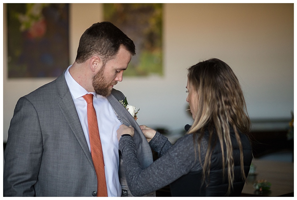 groom getting his boutonniere on for his elopement 