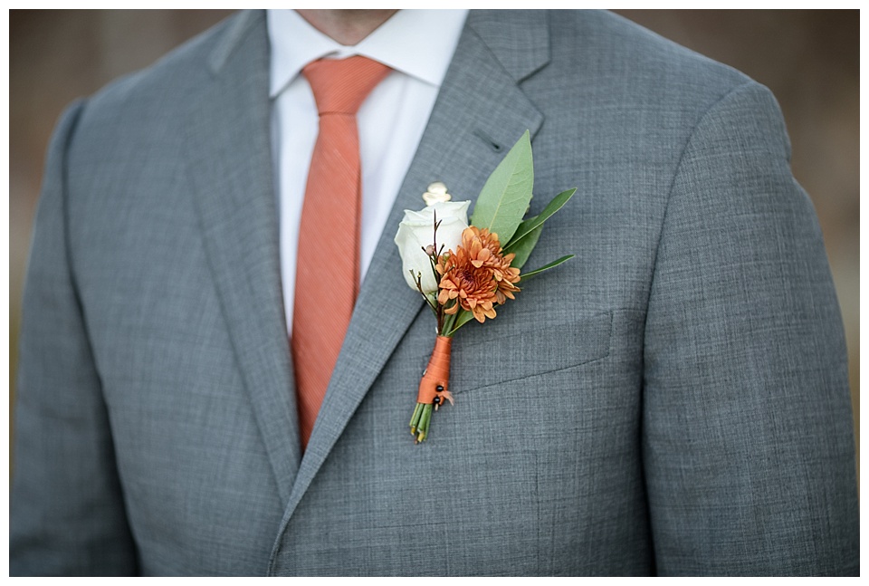 detail of grooms suit and flower