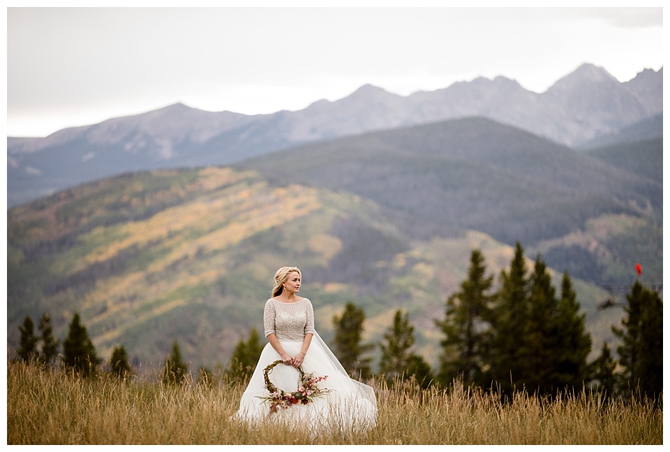 bride poses in the mountains at game creek club