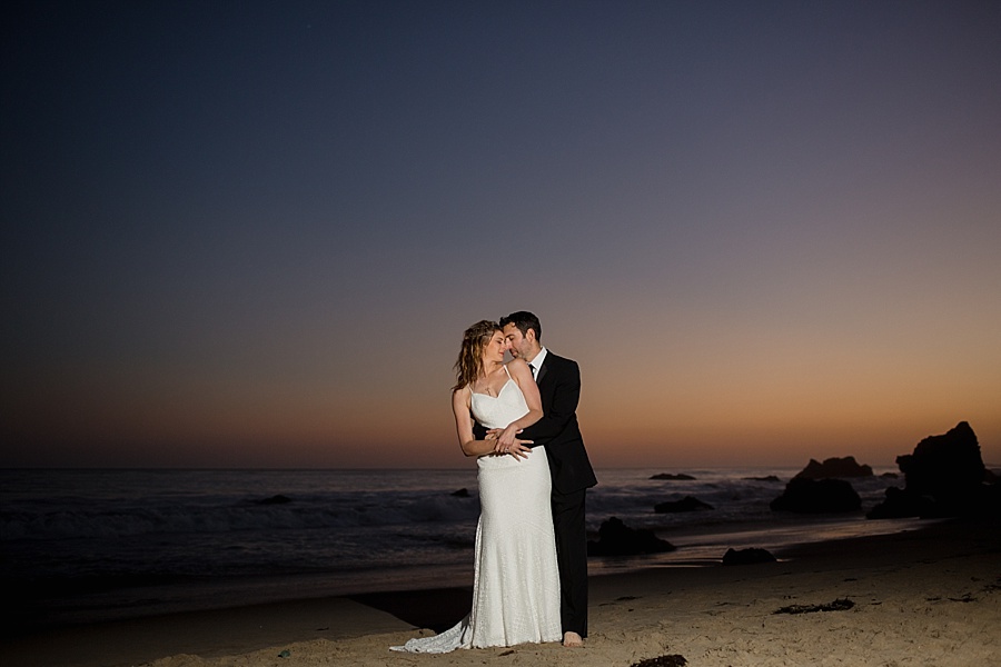 groom holds bride from behind at matador beach