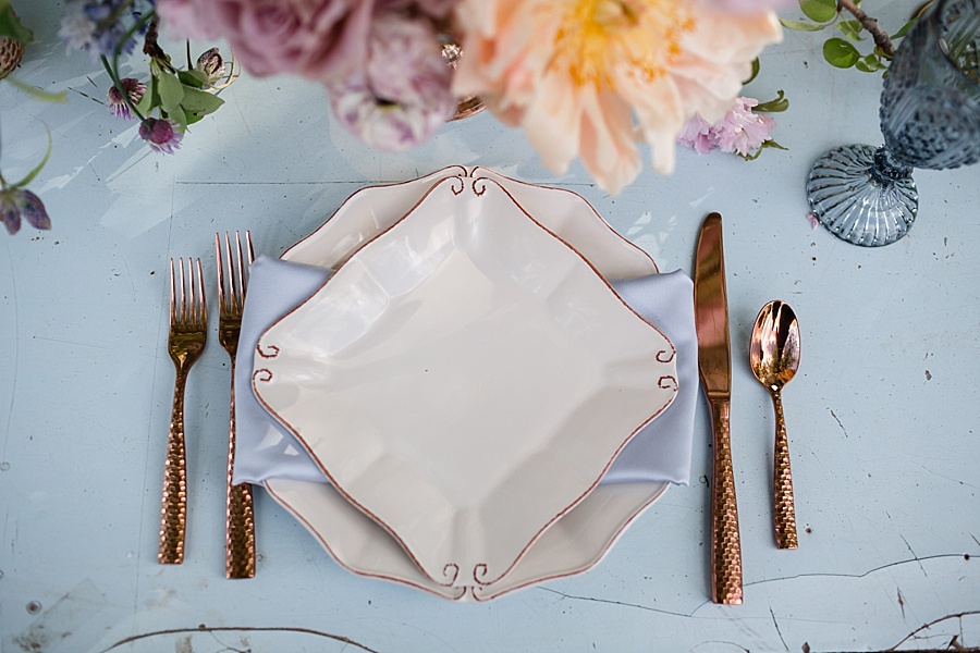 rose gold silverware and textured cream plates