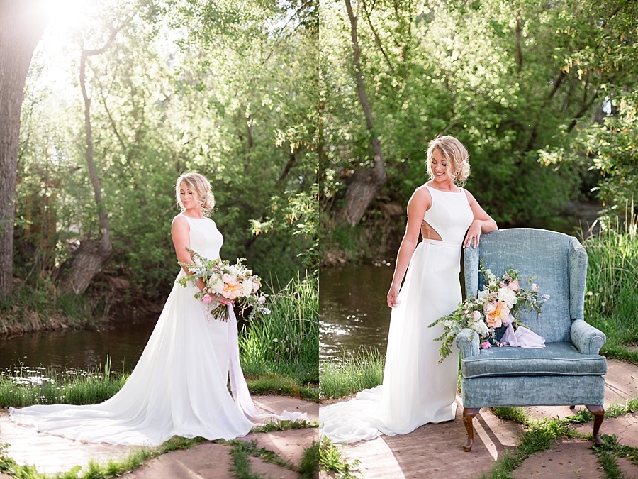 bride poses with blue couch and pastel floral bouquet