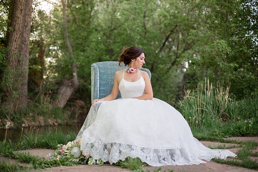 bride sits in blue couch with handmade floral choker